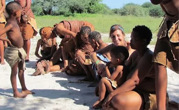 Nicole Apelian seated with San Bushmen community members during field research in Botswana.