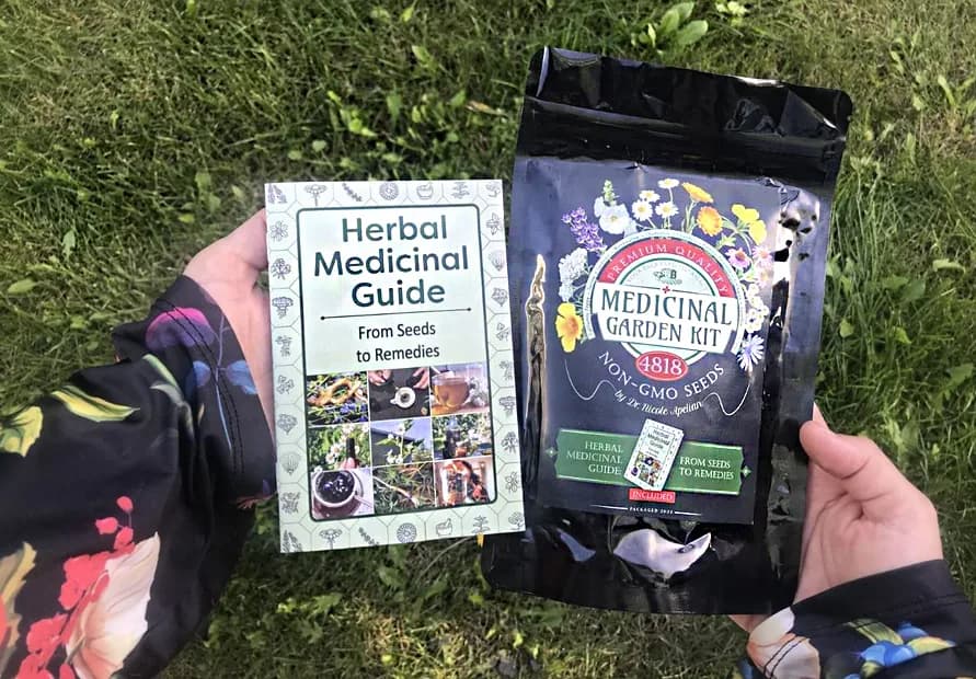 The Medicinal Garden Kit pouch marked 4,818 non-GMO seeds, held beside the printed Herbal Medicinal Guide: From Seeds to Remedies.